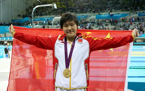 7月31日,叶诗文领奖后身披国旗庆祝。当日,在伦敦奥运会游泳女子200米个人混合泳决赛中,中国选手叶诗文以2分07秒57的成绩获得冠军,并创造新的奥运会纪录。新华社记者 费茂华 摄