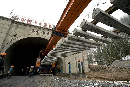 精伊霍铁路铺轨到伊犁河谷 3月31日,在新疆尼勒克县境内的精伊霍铁路北天山隧道出口,铺轨机正将一节轨排放置到隧道外的路基上,这标志着精伊霍铁路已铺轨到伊犁河谷。 精伊霍铁路(精河-伊宁-霍尔果斯口岸)是国家重点建设工程,也是新疆首条电气化铁路,起于乌鲁木齐至阿拉山口铁路的精河站,穿过北天山主岭,经伊犁到达终点霍尔果斯口岸,全长285公里。目前,铺轨按期通过北天山隧道,随后将经伊犁直奔霍尔果斯,并有望于今年年底建成。 新华社发(刘成刚 摄)