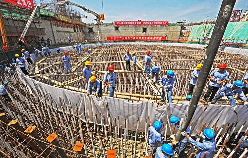 7月17日,工人们在为秦山核电站扩建工程2号机组核反应堆厂房基础浇注第一批混凝土。新华社记者 谭进 摄