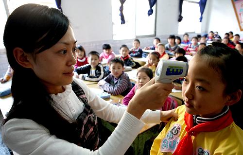 11月3日,刚复课的四川华蓥市双河小学学生在课间接受体温检测。新华社发(邱海鹰 摄)