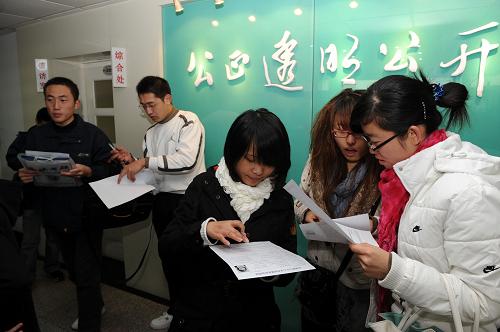 11月10日,几名考生在青岛招办研究生报名点核对网上报名信息。 当日起到14日,2010年全国硕士研究生统一入学考试报名进入现场确认阶段。考生应在此期间凭有关证件到网上报名选定报考点进行信息确认、缴费和照相。根据教育部规定,网上报名信息必须经过现场确认方为有效。 新华社记者 李紫恒 摄