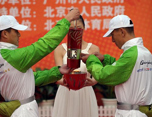 10月9日,圣火护卫队员点燃火种灯。当日,第16届亚洲运动会火种采集仪式在北京居庸关长城北烽火台举行。 新华社记者王毓国摄