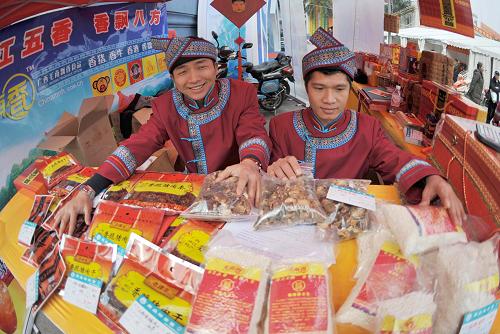 1月12日,在广西南宁市广西展览馆,来自环江毛南族自治县的毛南族同胞在推介毛南“五香”系列品牌特产。新华社记者 周华 摄