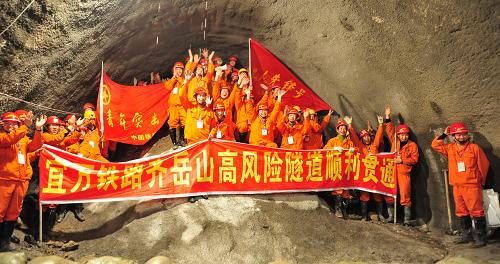 这是2009年12月10日,宜万铁路建设者欢庆宜万铁路最后一座Ⅰ级风险隧道——齐岳山隧道正式贯通。宜万铁路东起湖北宜昌,西至重庆万州,工程于2004年开工,全长377.46公里,共有隧道159座,桥梁253座,桥隧占线路总长的74%,总投资225.7亿元,计划2010年全线建成通车运营。新华社发(杨顺丕 摄)