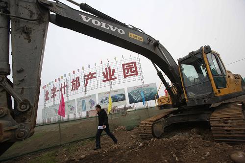 1月26日,一名工作人员从北京什邡产业园建筑工地走过。北京什邡产业园规划面积9平方公里,起步区3.1平方公里。目前正实施区内道路、变电站、自来水厂、搬迁房小区等基础设施建设。已有多家北京企业与什邡市政府签订了投资意向性协议。2009年,北京对口援建四川省什邡市工作全面推进。截至2009年底,先后确定3批对口援建项目108个,确定援建资金70亿元。其中已开工项目93个,竣工50个。新华社记者 汪永基 摄