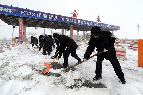 4月13日,哈同公路(哈尔滨至同江)管理处金家收费站的工作人员在清理路面积雪。新华社记者 李勇 摄