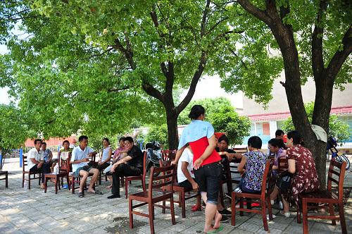7月29日,转移后的群众在武汉市蔡甸区玉贤镇农力村的大树下乘凉。新华社记者 郝同前 摄