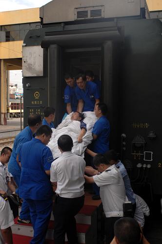 8月27日,一名伤员被抬下火车。新华社记者 王松 摄