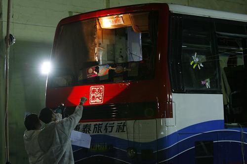 8月30日,在菲律宾大马尼拉地区塔吉格市,香港调查组工作人员勘察被劫持的大客车。新华社发(鲁埃勒·乌马利摄)