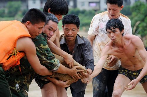 6月26日,福建武警官兵和当地干群在搬石头抢修便桥。当日,在武警福建总队官兵及当地干群的协力救援下,福建顺昌县元坑镇宝庄村400多名受困群众通过临时搭建的便桥安全转移。至此,福建受洪涝灾害被困时间最长、救援任务最艰巨、救助条件最恶劣的“孤岛”宝庄村被“攻下”。 元坑镇宝庄村,位于海拔1304米的宝山南侧。6月18日以来,宝庄村受特大暴雨冲袭,山洪、泥石流摧毁入村的道路和桥梁,电力、通讯中断,480多名村民被困,其中有5名孕妇。新华社记者 姜克红 摄