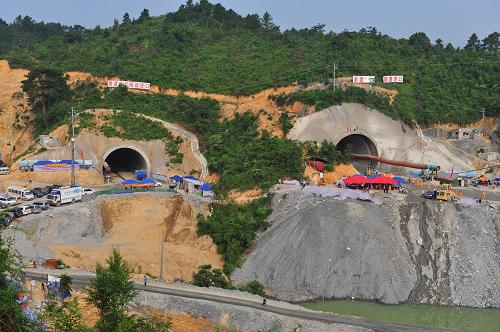 这是7月16日拍摄的新建南黎铁路那适1号(右)、2号隧道。当日,广西宾阳隧道塌方事故进入第六天,从1号隧道通往塌方的2号隧道的横向救援通道有望今日打通。11日15时56分,新建南黎铁路那适2号隧道NGDK698+382仰拱前方发生坍塌,10名工人被困。 事故发生后,有关部门迅速组织力量开展抢险救援工作,并确定了横向、纵向和垂直方向的三套救援方案。正当救援工作逐步展开的时候,14日上午,发生事故的2号隧道再次发生两次塌方,使救援工作受阻。新华社记者 黄孝邦 摄