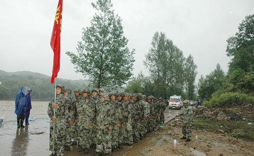 7月31日,沈阳军区某部救援官兵在安图县万宝镇列队准备救援。当日,随着吉林省安图县万宝镇洪水有所减退,250名解放军官兵为这座“孤岛”打通了生命补给线,共向该镇运送60吨救灾物资,确保当地受灾群众使用10天左右。受连日暴雨影响,吉林省安图县境内大沙河河水漫堤,多条乡镇公路被大水冲毁,万宝镇等地一度成为“孤岛”。新华社记者 王猛 摄