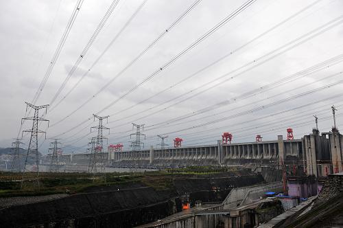 这是三峡大坝及电力输出线路和右边正在建设中的升船机(10月25日摄)。10月25日17时,三峡上游水位达到174.81米,入库流量为每秒12800立方米。中国长江三峡集团公司25日召开新闻发布会宣布,根据调度安排,三峡工程将于10月26日上午9时实现175米蓄水目标。新华社记者 郝同前 摄