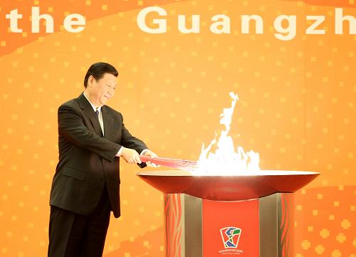 12月4日,中共中央政治局常委、国家副主席习近平在北京人民大会堂出席广州2010年亚洲残疾人运动会火炬点燃暨火炬传递活动启动仪式。这是习近平点燃广州亚残运会火炬。新华社记者 丁林 摄