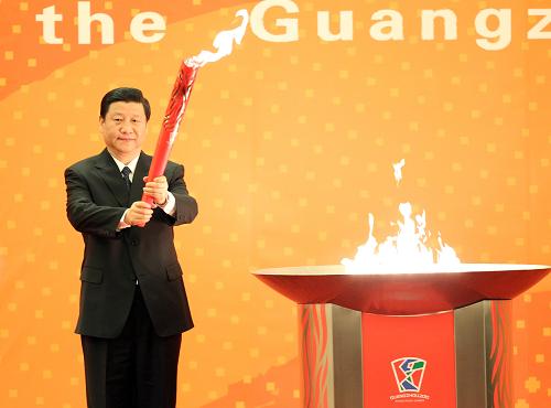 12月4日,中共中央政治局常委、国家副主席习近平在北京人民大会堂出席广州2010年亚洲残疾人运动会火炬点燃暨火炬传递活动启动仪式。这是习近平举起点燃的广州亚残运会火炬。新华社记者 丁林 摄