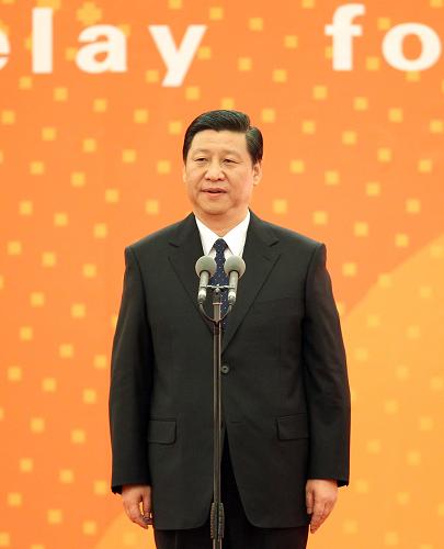 12月4日,中共中央政治局常委、国家副主席习近平在北京人民大会堂出席广州2010年亚洲残疾人运动会火炬点燃暨火炬传递活动启动仪式。这是习近平举起点燃的广州亚残运会火炬。新华社记者 丁林 摄
