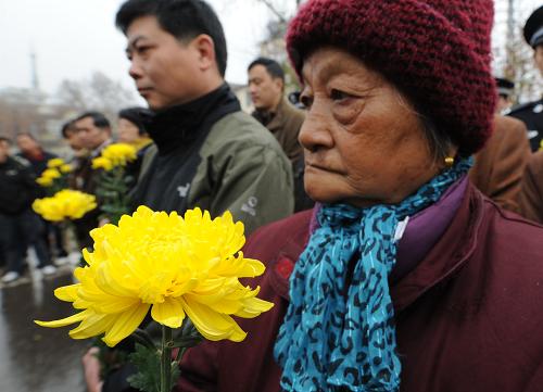 12月13日,大屠杀幸存者仇秀英老人(右)参加在“侵华日军南京大屠杀中山码头遇难同胞纪念碑”前举行的悼念仪式。当日,南京各界群众集会悼念侵华日军南京大屠杀30万同胞遇难73周年。在南京下关“侵华日军南京大屠杀中山码头遇难同胞纪念碑”前的分会场,来自各单位和街道社区的机关干部、市民群众、部队官兵及大屠杀幸存者代表一同举行悼念仪式,凭吊遇难同胞。新华社记者 孙参 摄