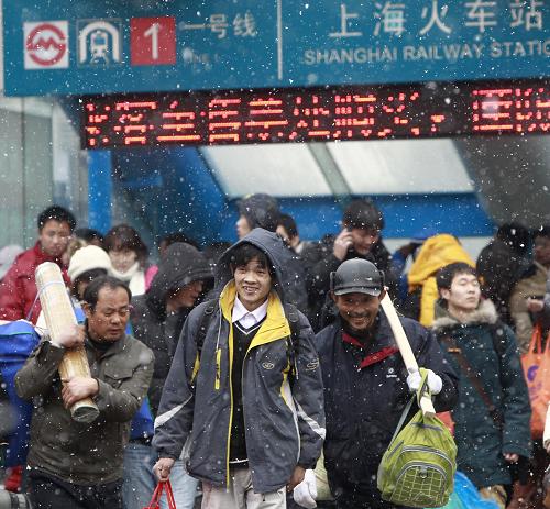 1月18日,旅客正冒雪前往上海火车站乘车。为期40天的2011年春运将于1月19日正式启动。春运期间,全国旅客运量预计将达到28.53亿人次,比上年春运增长11.6%,全国铁路预计发送旅客2.3亿人次,同比增加2554万人次,增长12.5%。新华社记者 裴鑫 摄