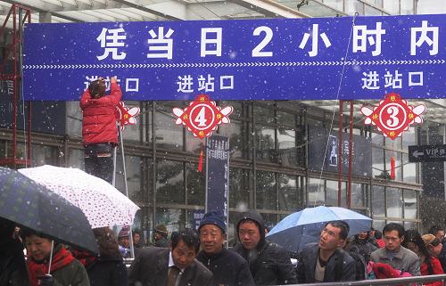 1月18日,旅客冒着风雪在铁路上海站进站候车。 当日,上海迎来降雪。上海铁路春运将于19日正式启动,铁路部门已采取开启地下临时候车点等措施应对风雪天气。新华社发