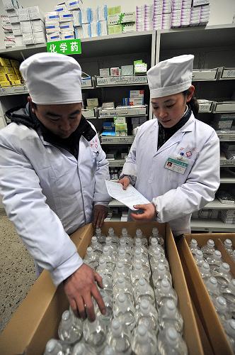 在安徽省蚌埠市固镇县城关镇卫生院,药房负责人在清点配送到的药品(1月19日摄)。新华社记者 何俊昌 摄