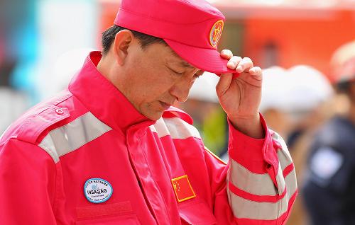3月1日,一名中国救援队队员在新西兰克赖斯特彻奇市中心大教堂前为地震死难者默哀。新西兰全国各地的民众以及正在当地的各国救援队员于当地时间1日中午12时51分默哀两分钟,哀悼地震中的遇难者。新华社发