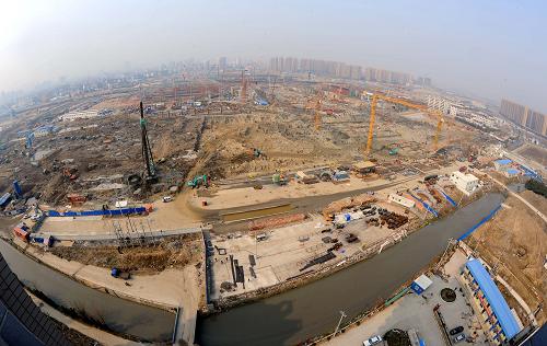 这是正在建设中的杭州铁路东站枢纽工程(3月10日摄)。正在建设中的杭州铁路东站枢纽工程是目前浙江省内最大的铁路枢纽工程,主体工程将于2011年年底完工,2012年6月30日前正式投入使用。根据设计,杭州铁路东站站内自西向东设有宁杭甬、沪杭长、普速车3个到发场,30条到发线,到发线规模为目前国内最大。建成后的杭州铁路东站分为上下5层,乘客在站内就可以实现火车、地铁、公交、出租车的无障碍换乘,更具特色的是在站外就有运河码头可以乘坐水上巴士,成为名副其实的水陆交通枢纽。据初步估计,新东站的日均客流量将达30万人次左右。新华社记者 徐昱 摄