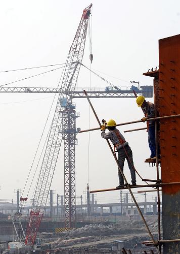 3月10日,工人在杭州铁路东站枢纽工程工地上施工。正在建设中的杭州铁路东站枢纽工程是目前浙江省内最大的铁路枢纽工程,主体工程将于2011年年底完工,2012年6月30日前正式投入使用。根据设计,杭州铁路东站站内自西向东设有宁杭甬、沪杭长、普速车3个到发场,30条到发线,到发线规模为目前国内最大。建成后的杭州铁路东站分为上下5层,乘客在站内就可以实现火车、地铁、公交、出租车的无障碍换乘,更具特色的是在站外就有运河码头可以乘坐水上巴士,成为名副其实的水陆交通枢纽。据初步估计,新东站的日均客流量将达30万人次左右。新华社记者 徐昱 摄
