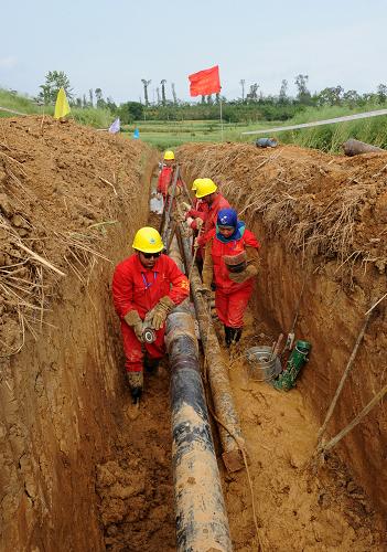 5月2日,中国石化西南石油局油田建设工程公司职工在四川绵阳安县塔水镇进行德阳至新北川的天然气管线铺设工作。四川德阳至新北川天然气管线工程是西南油气田的灾后重建项目,管道全长62千米,日输气能力为40万立方米,包括改扩建站场2座,新建站场1座,预计今年6月完工供气。新华社发(胡庆明 摄)