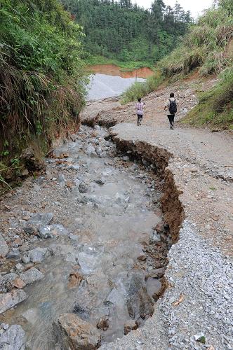 5月10日,广西全州县咸水乡洛江村广坑槽屯,从采石场流出的水流将道路冲毁近半。截至5月10日12时,发生在广西全州县咸水乡洛江村广坑槽屯一石料厂上方的山体泥石流灾害,除了1人生还外,已造成6人死亡,16人失踪。新华社记者 周华 摄