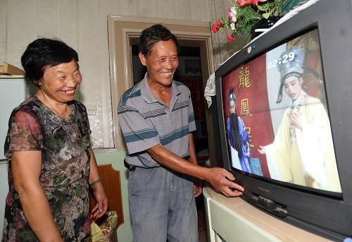 6月23日,浙江诸暨市江藻镇墨城坞村村民寿旺培夫妇打开电视机看电视。当日,浙江省诸暨市一支350余人的电力抢修突击队赶赴江藻镇灾区抢修受损的电力设施。一天内更换5只变压器,1634只电表,使断电一周的江藻镇的受灾村庄用户全部恢复了供电。受旱涝急转、连续强降雨和钱塘江潮位顶托等多重叠加影响,浙江诸暨市近日遭遇洪水袭击,供电设施受损,大批用户停电。当地电力公司迅速启动防汛应急响应,派出电力抢修突击队全力抢修受损的电力设施,恢复供电。新华社发(郭斌 摄)