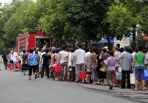 7月27日,四川绵阳市民在街头排队打水。绵阳市政府26日发布通告,阿坝州松潘县一电解锰厂21日受暴雨影响,矿渣流入涪江,绵阳市26日监测出涪江江油、绵阳段水质锰和氨氮超标,提醒市民不要饮用自来水。目前,绵阳市已采取集中送水、调度成品水等方式,解决饮用水问题。新华社发