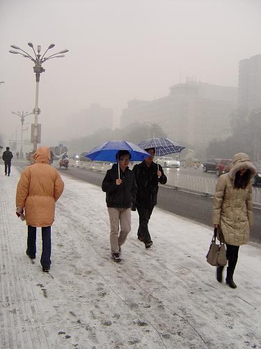 12月2日,人们走在北京一处积雪覆盖的人行道上。当日,北京降下今冬第一场雪,目前降雪仍在持续。新华社记者 徐子鉴 摄