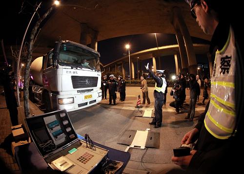2月7日夜,交警在对一辆大型水泥搅拌车进行称重。从2月6日开始,上海交警部门在全市范围内组织开展针对大型货运车辆(渣土车、混凝土搅拌车、环卫运输车辆等)交通违法行为的集中排查整治行动。在为期一周的整治行动中,交警部门将重点查处大型货运车辆超载、违反交通信号、故意遮挡、污损号牌等严重交通违法行为,以及非机动车超越行车线、闯红灯、逆向行驶和行人闯红灯等容易引发涉及大型货运车辆人员伤亡交通事故的交通违法行为。新华社记者 凡军 摄