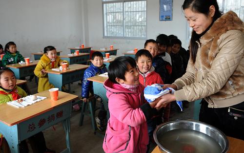 2月28日,安徽省六安市金寨县古碑镇宋畈小学的老师在为准备用课间营养餐的一年级学生洗手。当日,金寨县5万多名农村义务教育学生吃上了每人每天3元标准的营养餐。从2012年春季学期起,安徽省金寨、临泉、阜南、宿松等12个县的近140万名农村义务教育学生将享受到国家实施的营养改善计划试点待遇。中央财政每年将安排安徽省8亿多元资金,向这些学生提供每人每天3元的营养膳食补助。新华社发(陈力 摄)