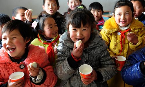 2月28日,安徽省六安市金寨县古碑镇宋畈小学学生在课间吃营养餐。当日,金寨县5万多名农村义务教育学生吃上了每人每天3元标准的营养餐。从2012年春季学期起,安徽省金寨、临泉、阜南、宿松等12个县的近140万名农村义务教育学生将享受到国家实施的营养改善计划试点待遇。中央财政每年将安排安徽省8亿多元资金,向这些学生提供每人每天3元的营养膳食补助。新华社发(陈力 摄)