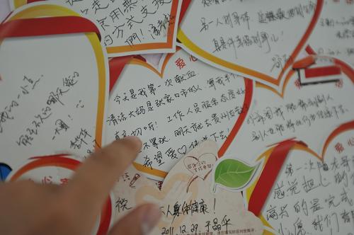 6月14日,一名献血者在查看北京西单献血站内墙壁上贴着的献血者留言。当日是第9个世界献血日,今年献血日的主题是“每位献血者都是英雄”。新华社发(刘长龙 摄)
