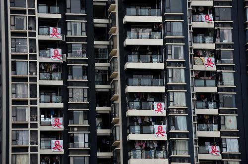 7月,在位于广西南宁市柳沙半岛的“大观天下”小区里,不少房屋业主在阳台上挂出大幅白底红字的“臭”字,希望再次引起有关部门的重视,彻底改变长期以来困扰居民的空气污染问题。柳沙半岛三面被曲折流过的邕江环绕,位置优越,是南宁市近年来重点打造的纯商业居住区。但是从2009年以来,这里一直饱受臭味侵袭之苦:邕江对面的城南垃圾填埋场、养猪场、医疗垃圾焚烧中心不时散发出恶臭与浮尘,居民苦不堪言。7月正值高温酷暑,臭味频频来袭,当地居民最终将大大的“臭”字贴在了自家阳台以示不满(7月28日摄)。新华社记者 黄孝邦 摄