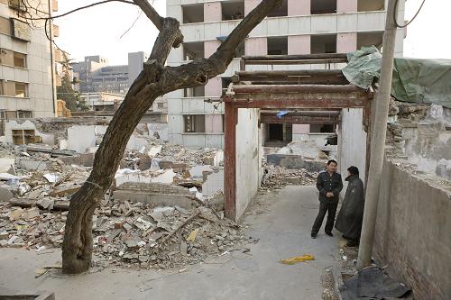 1月27日,保安在北京市东城区北总布胡同24号已被拆除的梁思成、林徽因故居旁聊天。1931年至1937年间,建筑大师梁思成、林徽因夫妇租住在北总布胡同3号四合院(现为24号院)。那是二人对中国建筑史及文物保护做出重要贡献的时期。同时,这座故居也成为20世纪30年代北平文化界人士重要聚会场所,哲学家金岳霖、作家沈从文和萧乾等都是这里的常客。从2007年起,多家地产开发商逐步对故居进行拆除,引发社会对于北京名人故居保护的争论。北京市文物局考虑将原址恢复修缮梁林故居。 新华社记者 沈伯韩 摄