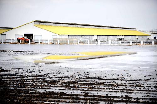 在黑龙江省双城市的一片雪水融化而无法下渗农田里倒映出远处的建筑(3月27日摄)。记者日前在黑龙江省产粮大县双城市看到,连片农田上依旧白雪覆盖,积雪融化无法渗入冰冻的土层,致使部分旱田变成“水田”。去年入冬以来,黑龙江省表现为总体气温低、降水多、积雪持续深的气候特点,截至目前各地农田大部分仍被积雪覆盖,大部地区3月中旬最大积雪深度在10厘米以上,春季内涝形势较严峻,给春耕生产带来不利影响。新华社记者 王建威 摄
