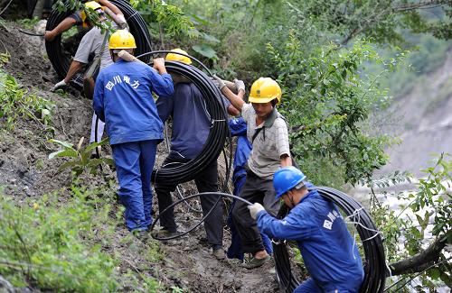 7月16日,在汶川县雁门乡麦地村,抢险队员与当地群众人拉肩扛运送电力抢险物资上山。7月16日,自贡供电公司驰援汶川抗洪保电抢险队展开“110千伏雁麦线”抢险施工。汶川110千伏雁门变电站位于汶川县雁门乡麦地村,这里是近期暴雨灾害的重灾区,民房、变电站及输电线路损毁严重,道路、桥梁也被冲毁。由于车辆无法开进,电力抢险所需的电杆、导线、施工机具等,全部需要人工运上海拔1000多米的高山。截至发稿时,“110千伏雁麦线”电力抢险物资全部运送到位,线路抢修已经完成约三分之一。新华社发(曾林 摄)