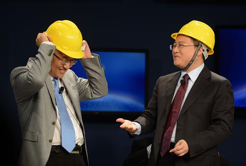 9月12日,网秦天下科技有限公司董事长兼联合首席执行官林宇(右)给北京大学经济学教授张维迎(左)戴安全帽。新华社记者 杨青 摄
