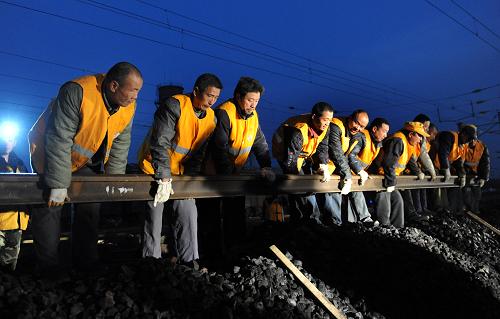 11月25日,郑州铁路局新乡桥工段施工人员在京广线汤阴站铺设铁轨。新华社记者 李博 摄