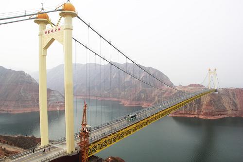 12月26日,汽车从折达公路刘家峡大桥上通过。 新华社发(史有东 摄)