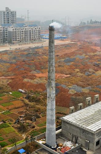 在湖南省邵阳市一处工厂,烟囱中排放出的烟雾飘向空中。(2013年12月26日摄)新华社记者 白禹 摄