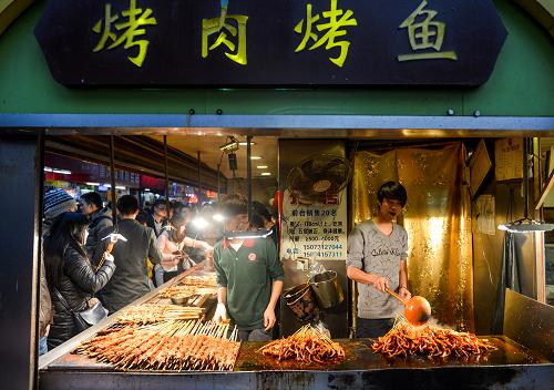 长沙市某商业街一处小吃摊正在制作烧烤食品(2014年1月12日摄)。新华社记者 白禹 摄