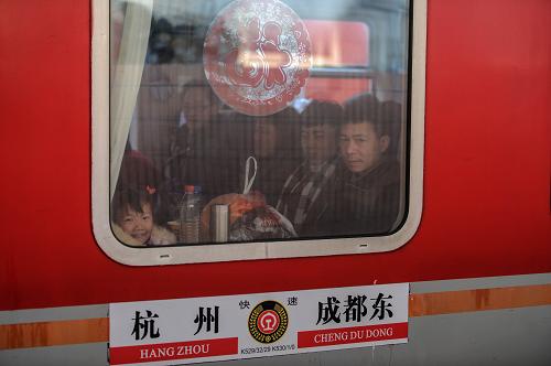 1月16日,杭州开往成都东的K529次列车上,乘客向车窗外张望。新华社记者 韩传号 摄