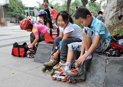 9月12日,南京师范大学附属小学的几名学生穿上轮滑鞋,准备参加“快乐周三”体育类活动。新学年伊始,南京市教育局推行的“快乐周三”活动在全市中小学校普遍展开,各校每周三下午由一节课后放学,改为组织开展“快乐周三”学生自主发展实践活动。新华社记者 孙参 摄