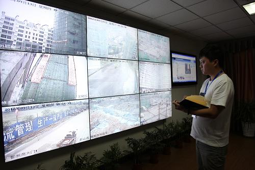 9月13日,在四川省眉山市“建安网”指挥中心,质监站工作人员利用“建安网”监测各地建筑工地施工情况。新华社发(姚永亮 摄)