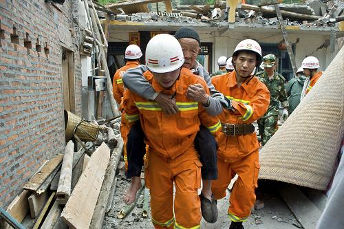 4月21日,甘孜消防地震救援队徒步40公里,用时8小时抵达地震重灾区宝兴县灵关镇,并立即展开搜救。这是当日13时左右,官兵在罗家村搜救时,成功救出一位八旬老人。新华社发(万康 摄)