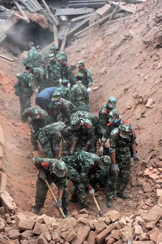 4月20日,武警四川总队一支队官兵在四川省芦山县清仁乡大片倒塌的房屋前进行搜救。新华社发(余坪 摄)